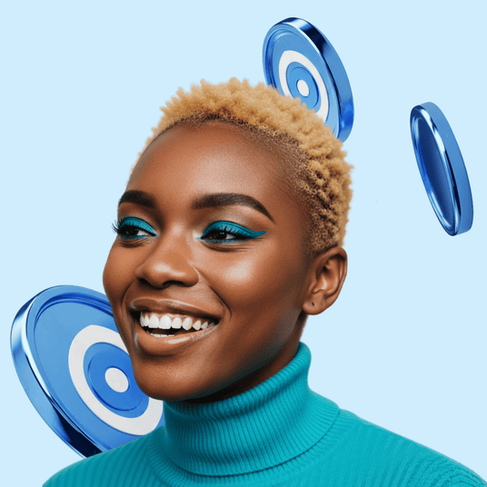 Woman with teal makeup and a turquoise sweater against a light blue background with blue circular objects.